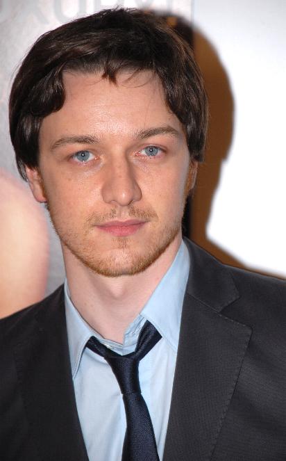 Close-up photograph of a young man with brown hair and blue eyes wearing a suit and tie.