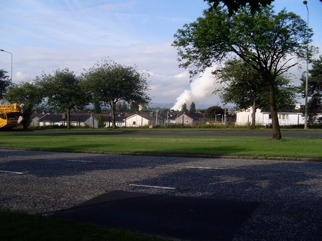 View of smoke rising from a scrapyard fire in Renfrew across a residential area and trees from Great Western Road.