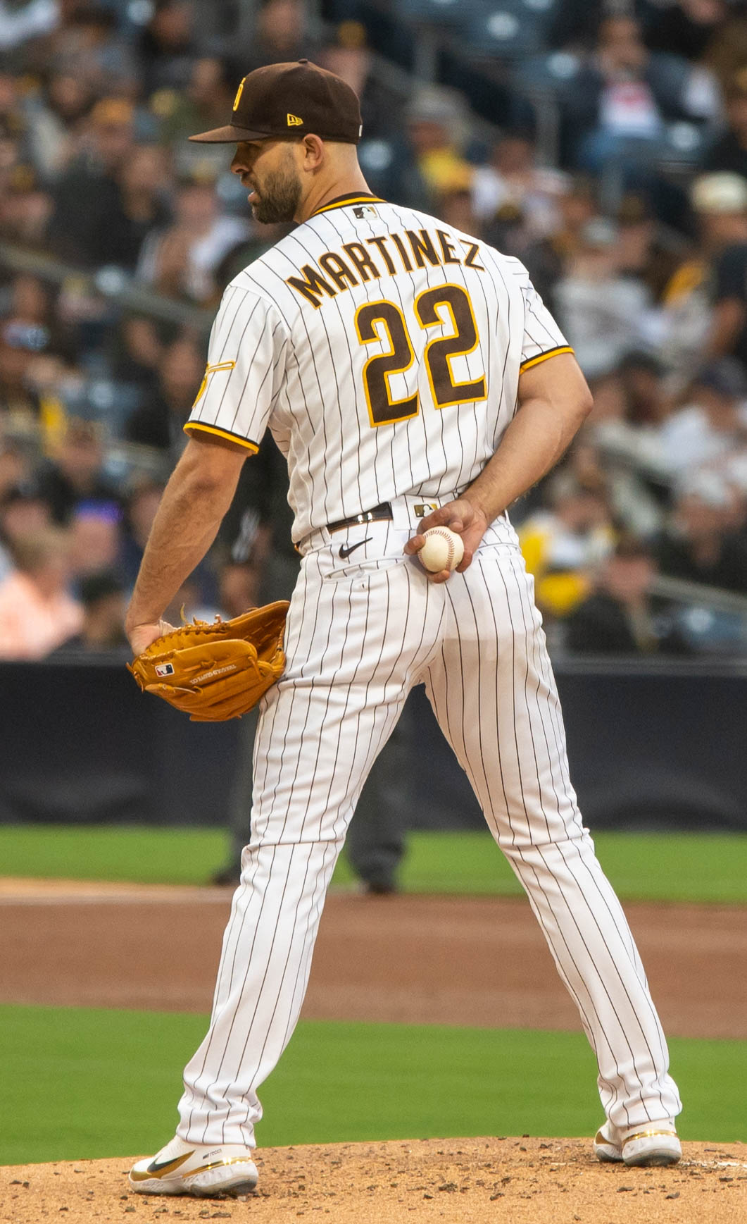 Baseball player Martinez wearing number 22 in a white pinstripe uniform preparing to pitch on the mound.