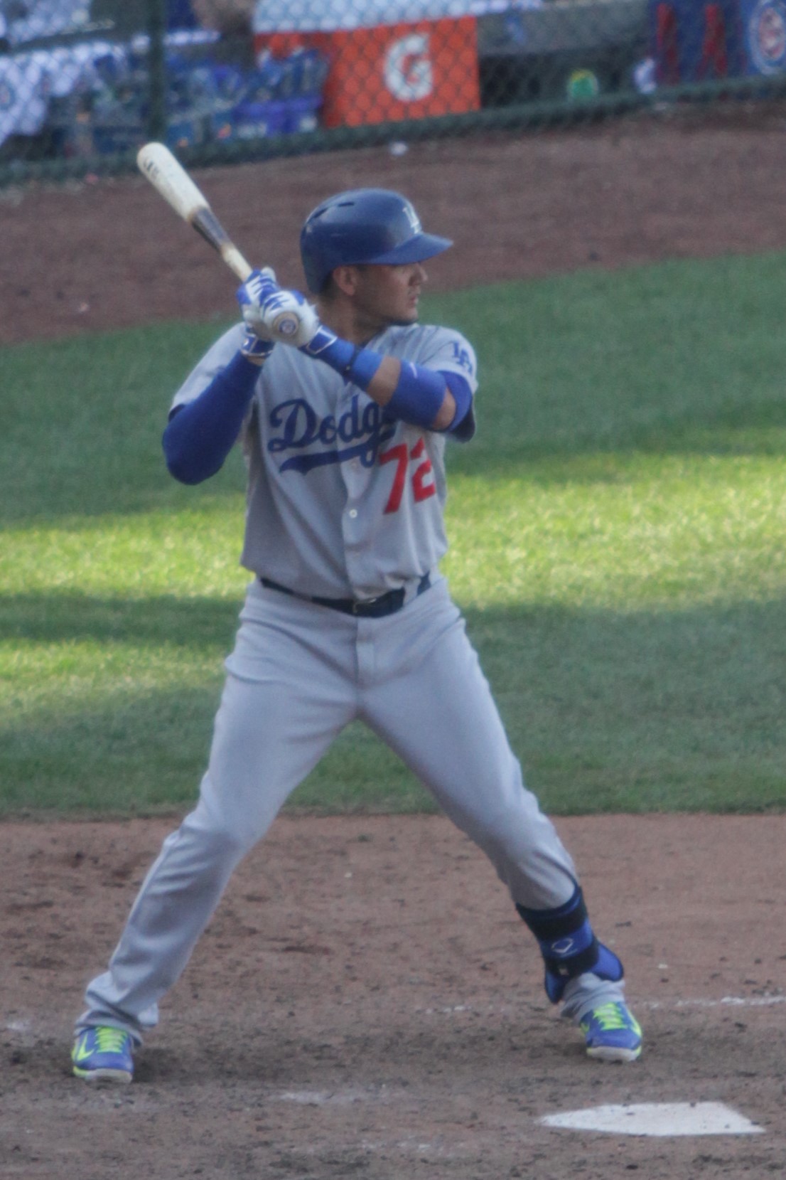 Miguel Rojas in Dodgers baseball uniform at bat in a stadium.