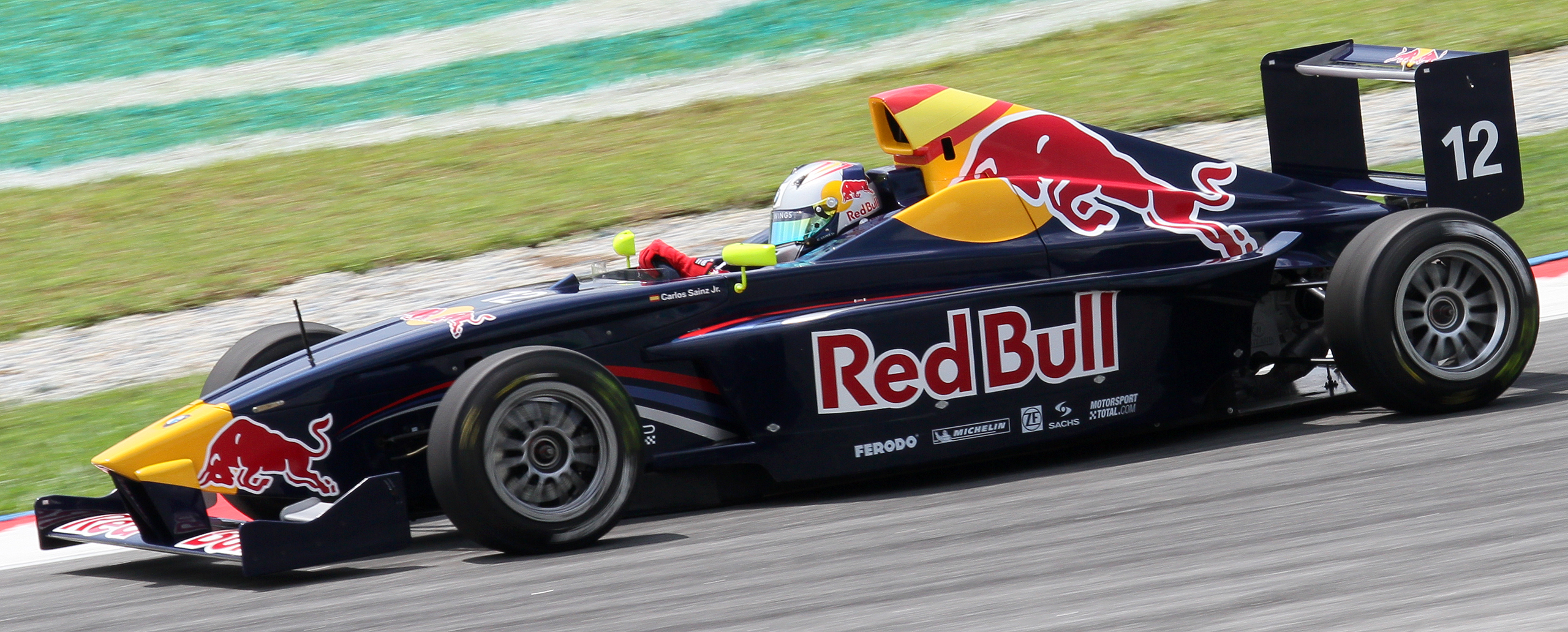 Carlos Sainz Jr. driving a Red Bull race car on a racetrack.
