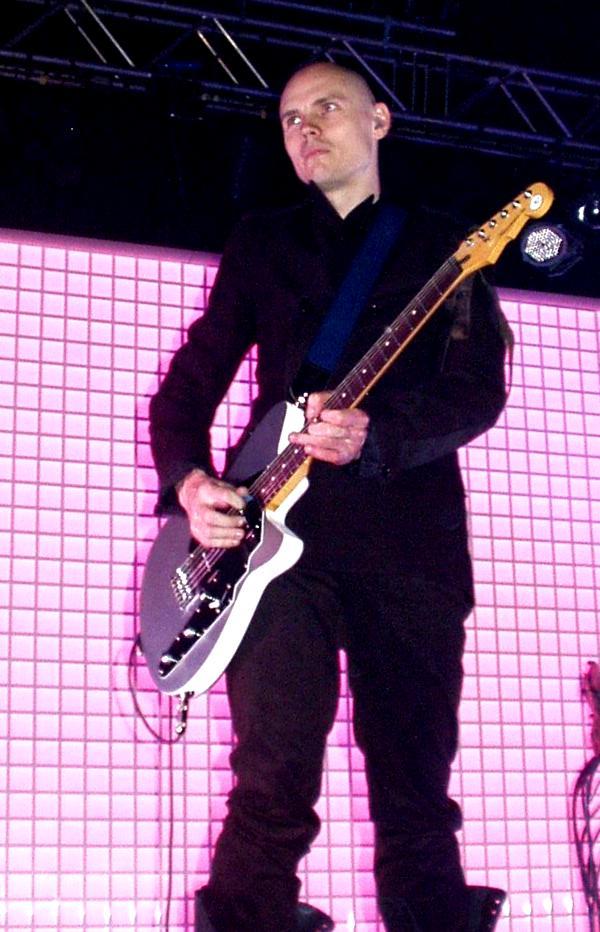 Billy Corgan playing electric guitar on stage at a concert.